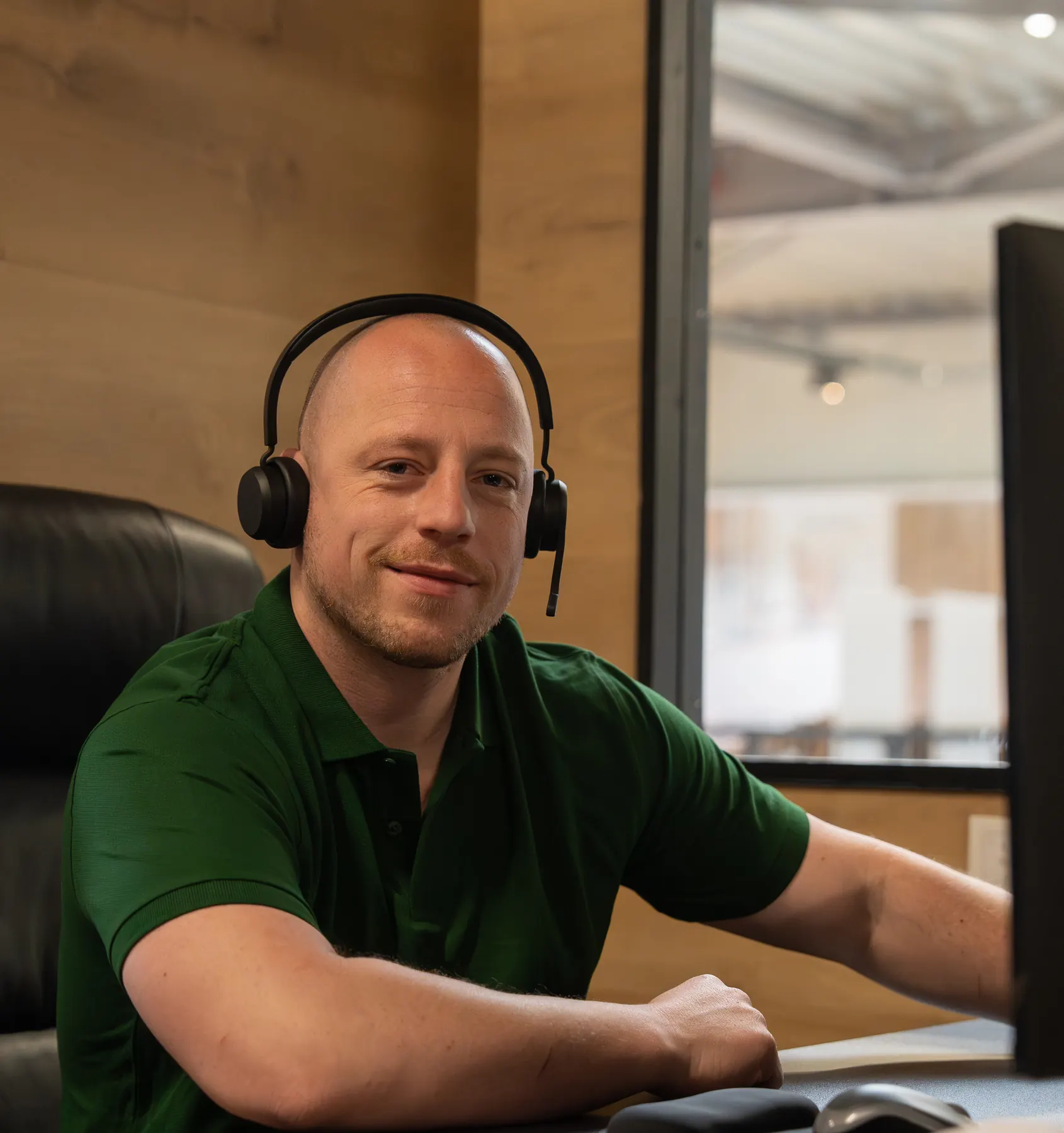 Nick, aanspreekpunt van VerhuisMeesters aan de telefoon, met een headset aan zijn bureau